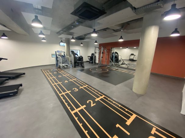 Remise en état après travaux cabinet kiné Salle de sport moderne avec tapis de course et équipements de musculation.