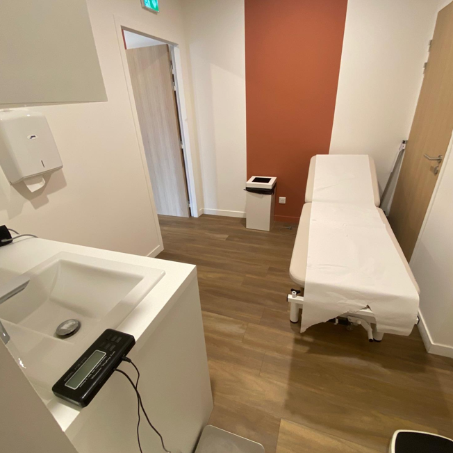 Cabinet dentaire avec un fauteuil, un équipement médical et une chaise d'invité.