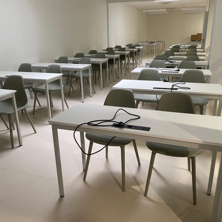 Salles de classe vides avec des tables et des chaises alignées.